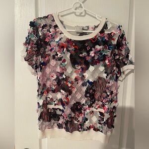 Blouse with appliqué flowers.